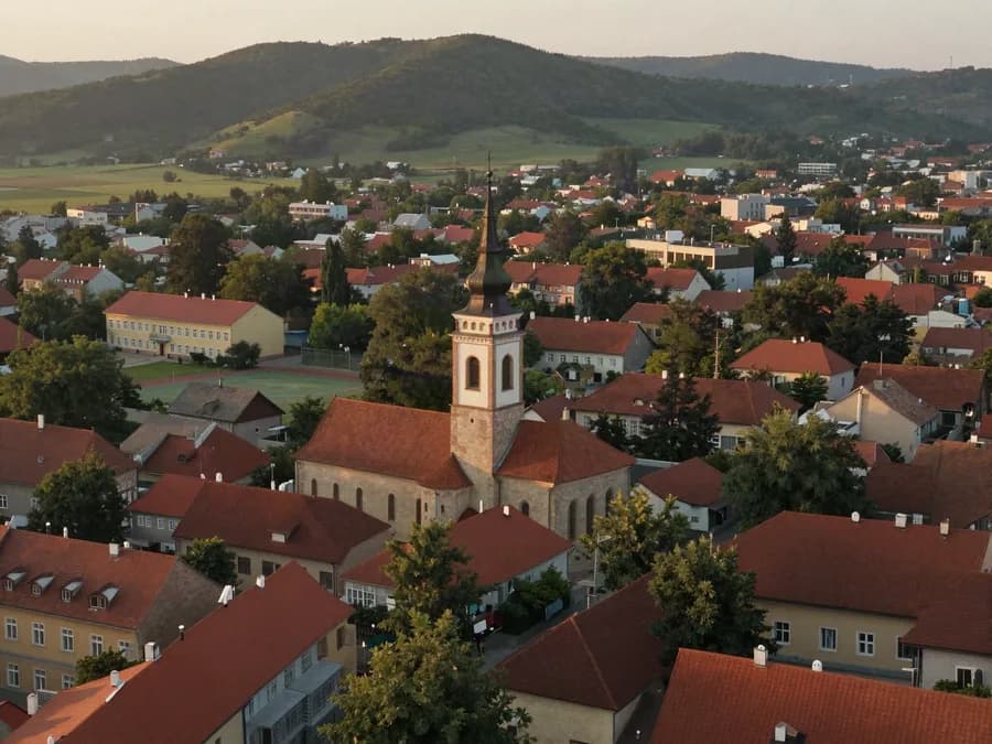 Pogled iz vazduha na varošicu sa crvenim krovovima i školom
